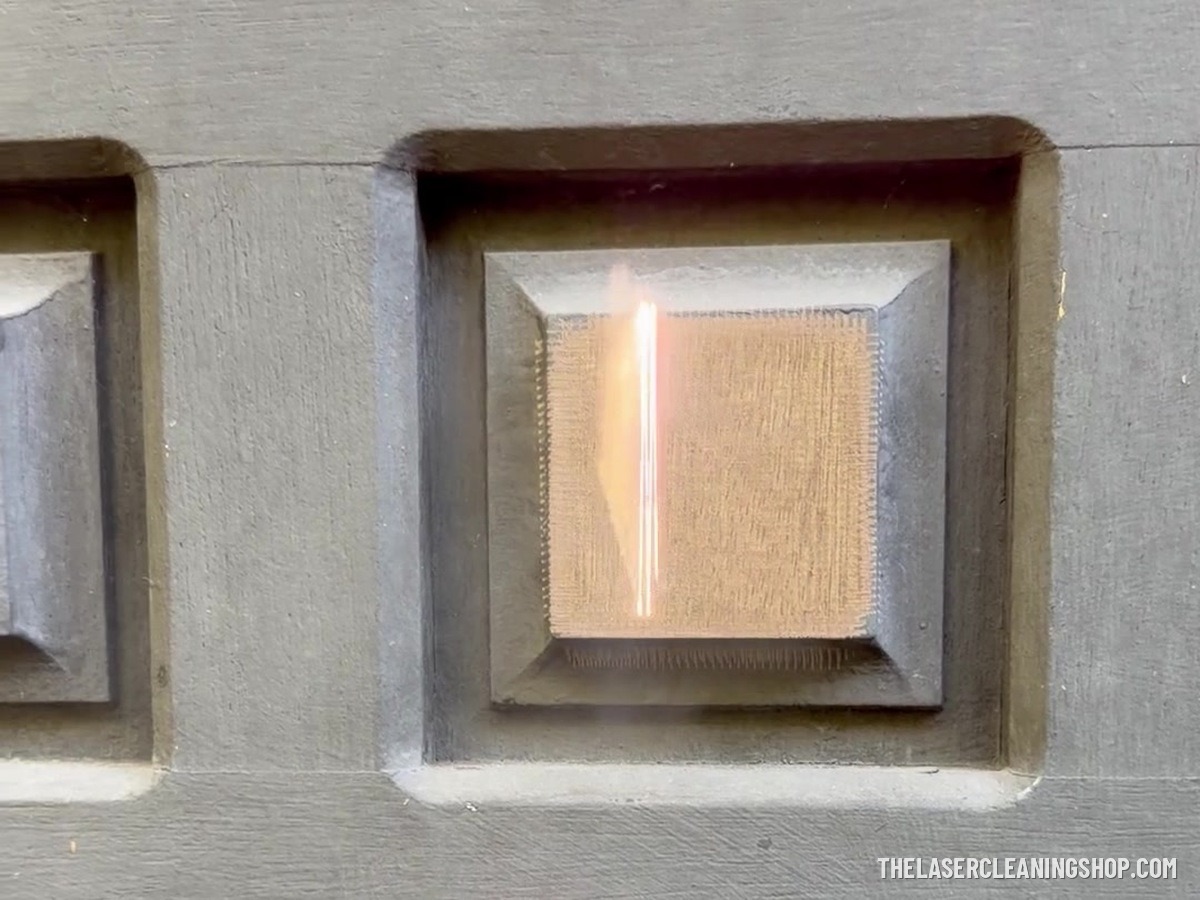 Laser removing paint from a raised panel on a residential mahogany front door, revealing bare wood — NJ