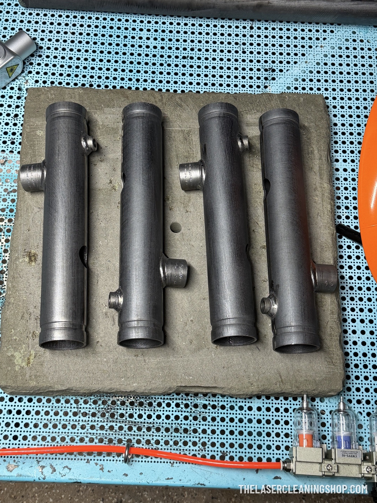 Steel manifold tubes laser cleaned to bare bright metal for a fire safety equipment manufacturer — industrial tooling NJ